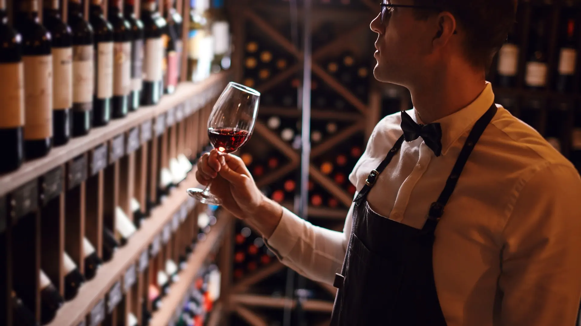 Sommelier prüft ein Glas Rotwein im Weinkeller