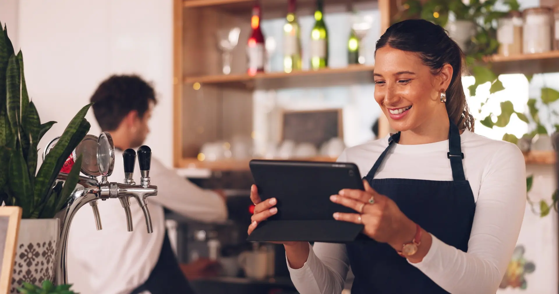 Mitarbeiterin an der Bar arbeitet mit dem Tablet
