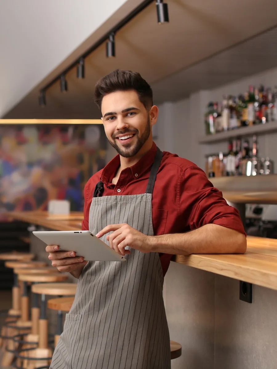 Barkeeper mit Tablet an der Bar